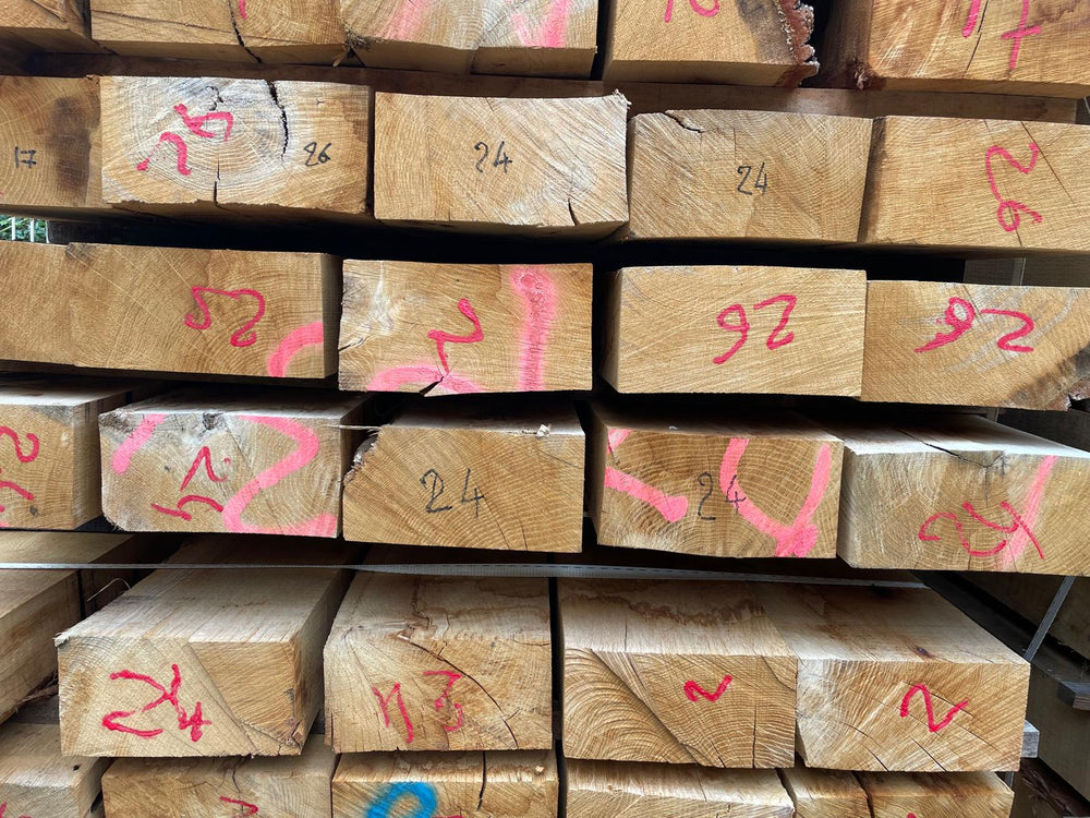 Pile de traverses paysagères en chêne en stock dans un entrepôt Articonnex